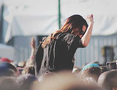 Девушка сидит на плечах человека на фестивале